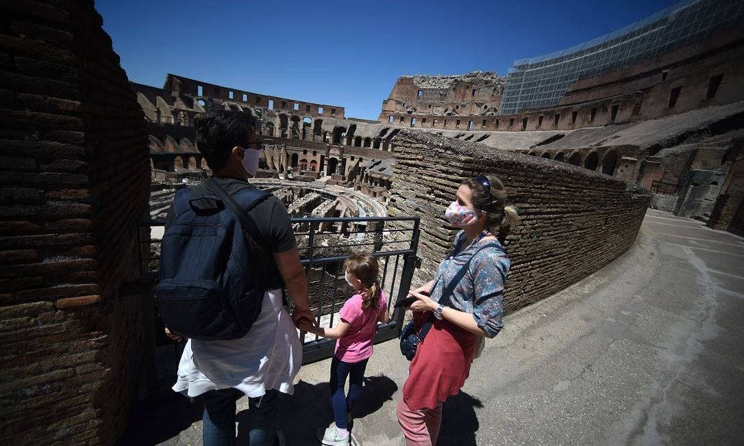 Uma família visita o Coliseu, em Roma, no dia de sua reabertura Foto: FILIPPO MONTEFORTE / AFP