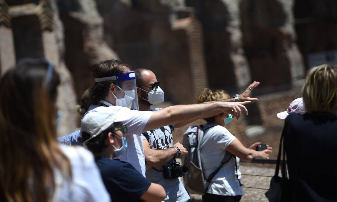 Guia e visitantes usando máscaras dentro do Coliseu no dia da reabertura do sítio histórico Foto: FILIPPO MONTEFORTE / AFP