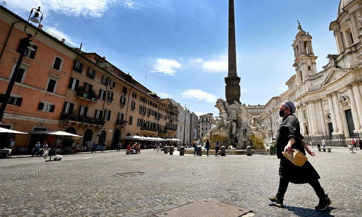 Um chef de cozinha caminha pela Piazza Navona, em Roma Foto: ALBERTO PIZZOLI / AFP