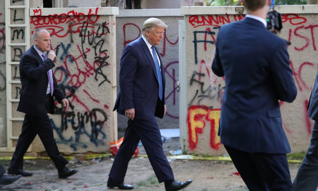 Donald Trump passa diante de prédio coberto por pichações perto da Casa Branca, no dia 1º de junho Foto: TOM BRENNER / REUTERS