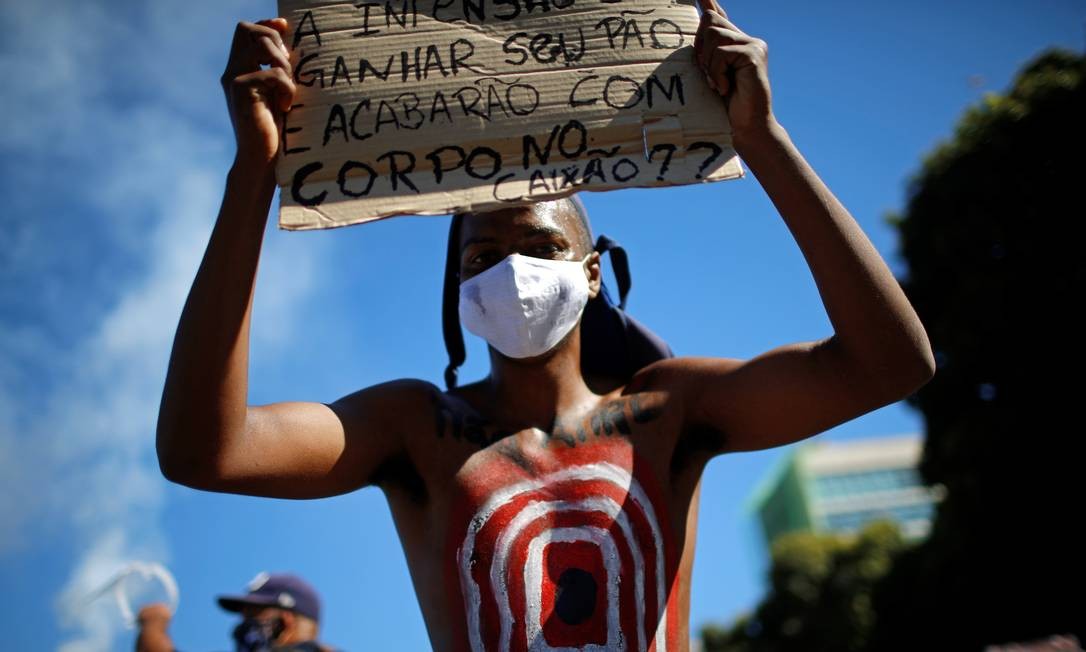 Jovem participa de ato em Brasília contra o governo, o racismo e de apoio à democracia Foto: ADRIANO MACHADO / REUTERS