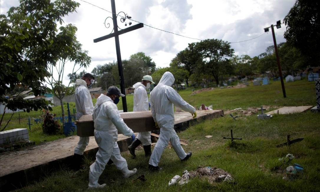 Em Breves,na Ilha de Marajó, no Pará, coveiros usam trajes de proteção para realizar o enterro de Manuel Farias, que morreu aos 70 anos Foto: UESLEI MARCELINO / REUTERS / 7-6-2020
