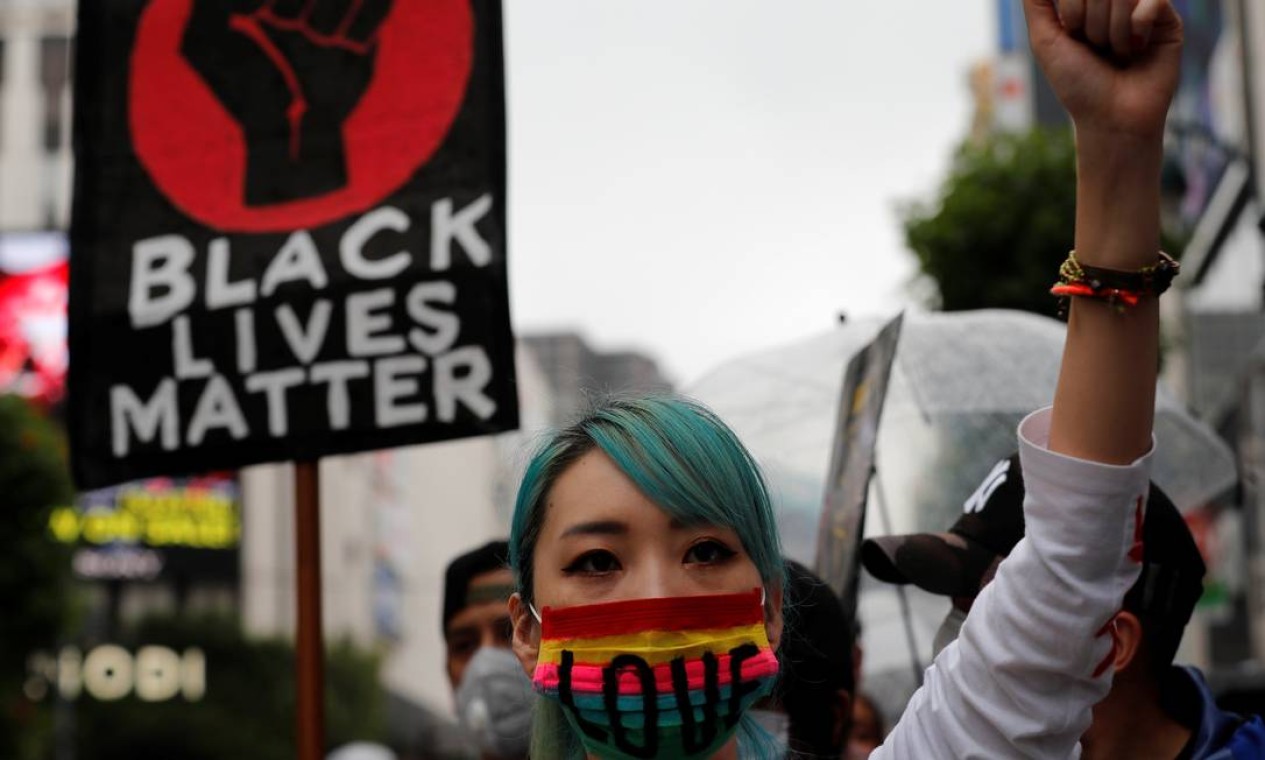 Uma jovem com máscara facial com a palavra "amor" participa de uma marcha do Black Lives Matter em Tóquio, Japão Foto: KIM KYUNG-HOON / REUTERS
