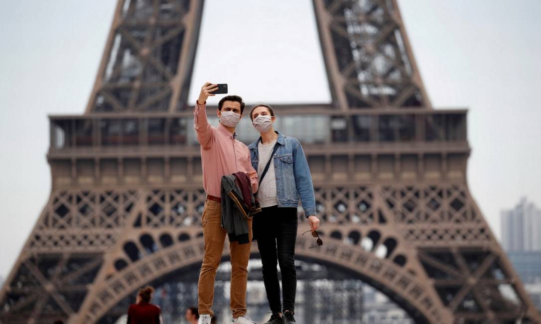 Em Paris, casal de máscaras tira foto em frente à Torre Eiffel Foto: Gonzalo Fuentes / REUTERS / 16-5-2020