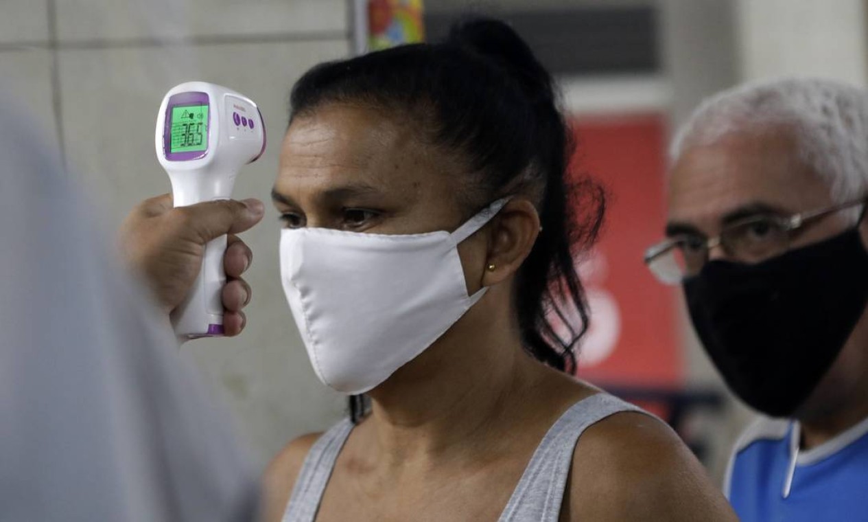 Protocolo: cliente tem a temperatura medida antes de entrar no Mercadão de Madureira, reaberto nesta quarta-feira Foto: Luiza Moraes / Agência O Globo