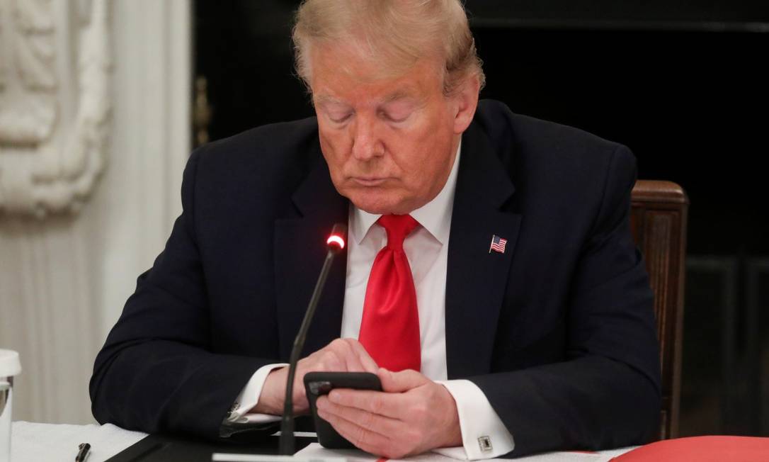 Presidente dos EUA, Donald Trump, digita no celular durante reunião na Casa Branca Foto: LEAH MILLIS / REUTERS / 18-6-2020