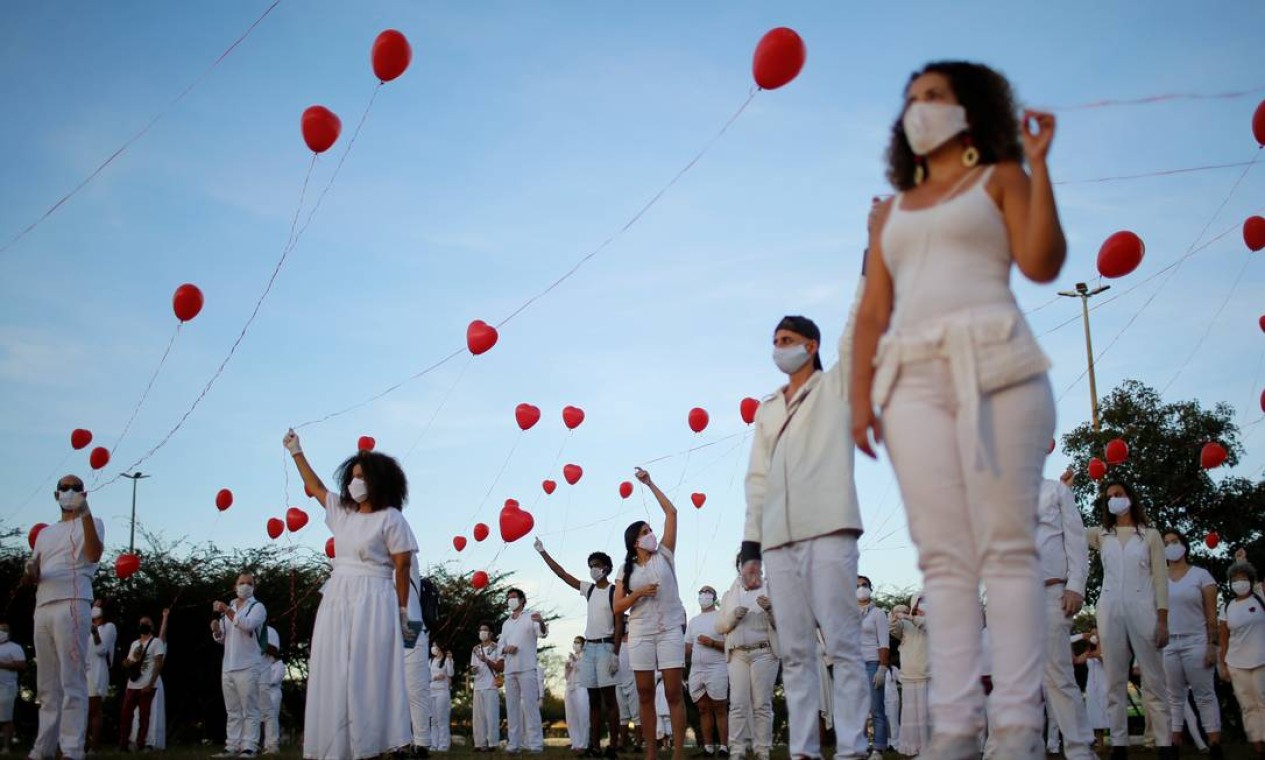 Artistas com balões vermelhos protestam em homenagem a pessoas que morreram pela COVID-19 no país, em Brasília Foto: ADRIANO MACHADO / REUTERS