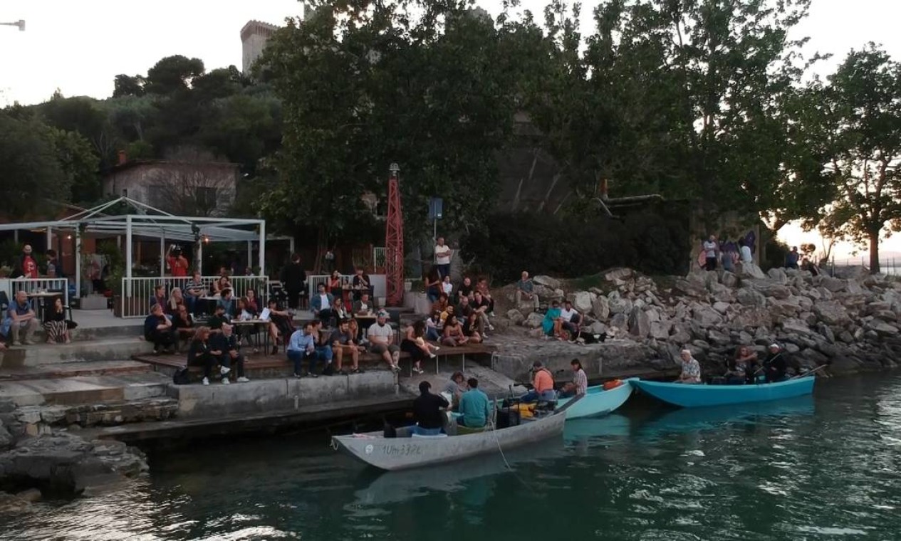 Músicos se apresentam em pequenos barcos de pesca no lago Trasimeno, para garantir o distanciamento social durante uma apresentação depois que a Itália aliviou as restrições contra a propagação do novo coronavírus, no lago Trasimeno, Itália Foto: REUTERS TV / REUTERS