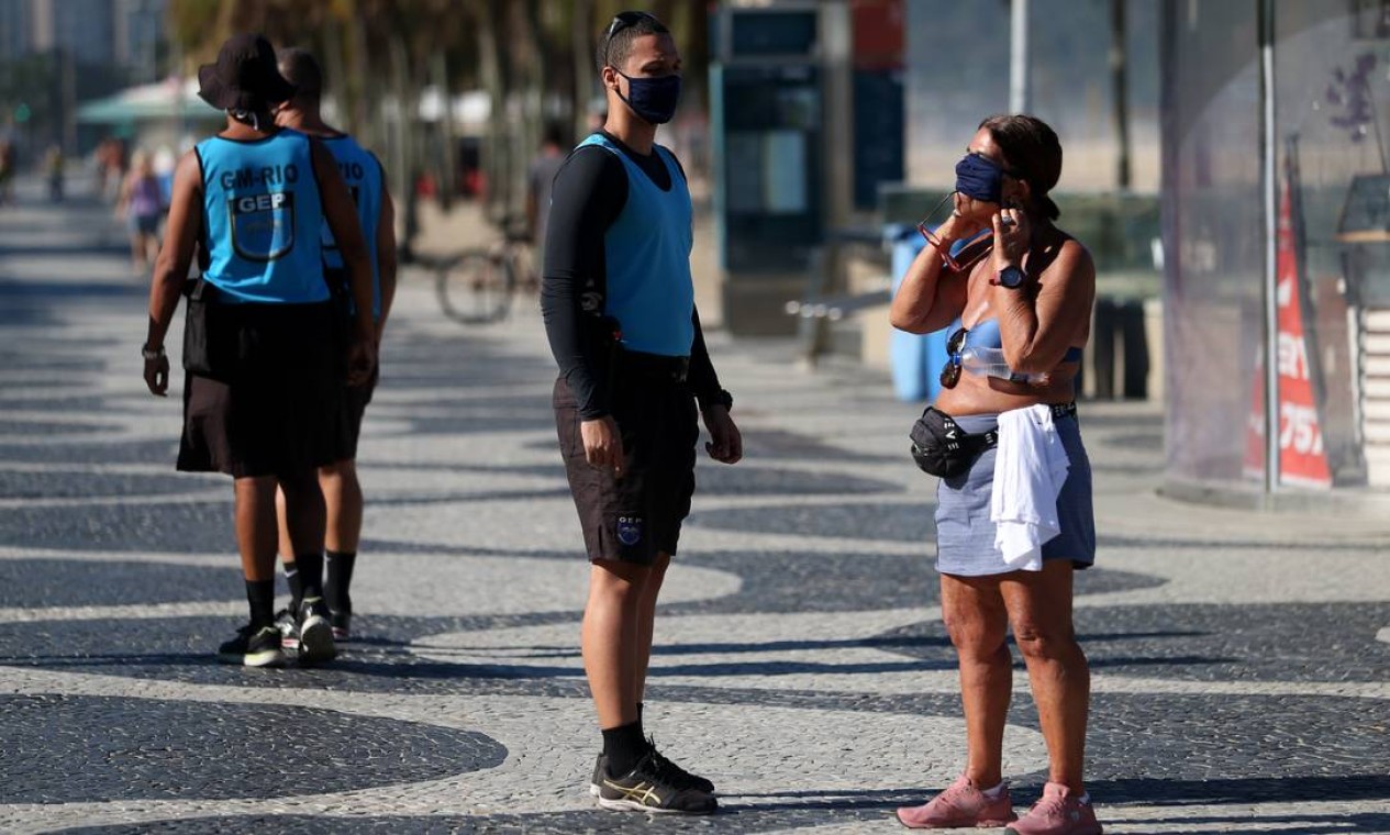 Guarda orienta pedestre a utilizar máscara, no calçadão de Copacabana. Agentes aplicaram multas a quem desrespeitava a regra nesta segunda-feira (22) Foto: Luiza Moraes / Agência O Globo