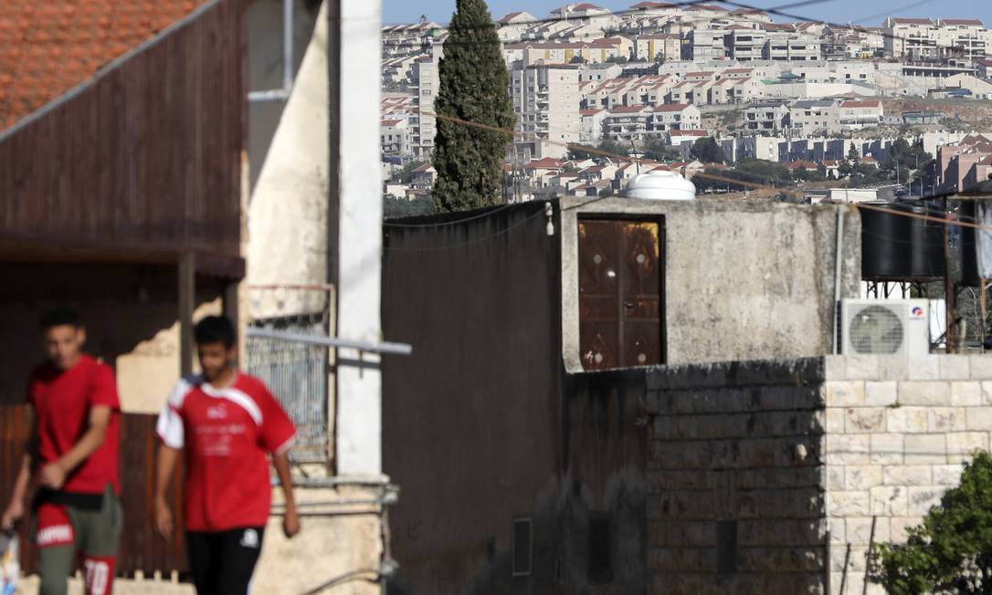 Vilarejo de Qirah, no sul de Nablus, na Cisjordânia ocupada. Ao fundo, assentamento israelense Foto: JAAFAR ASHTIYEH / AFP