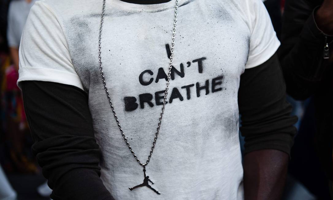 Manifestante veste blusa estampada com a frase em inglês "eu não consigo respirar", dita por George Floyd antes de morrer sufocado por um policial em 25 de maio Foto: CLEMENT MAHOUDEAU / AFP/13-06-2020
