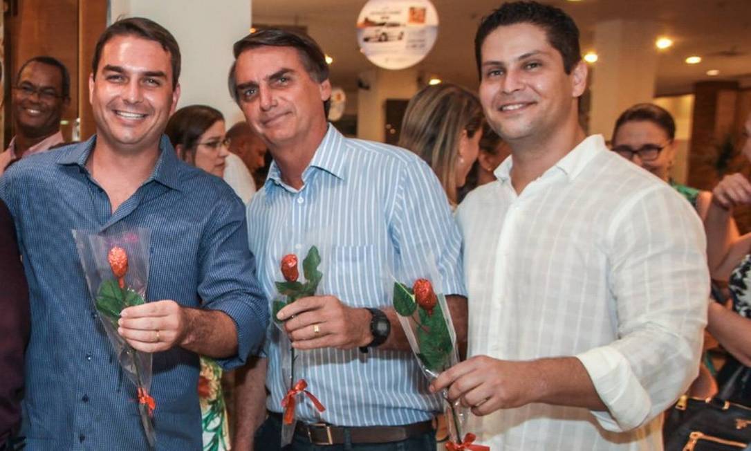 O senador Flávio Bolsonaro durante inauguração de sua loja de chocolates, em shopping do Rio, ao lado do pai Jair Bolsonaro e o sócio Alexandre Santini Foto: Reprodução/Facebook