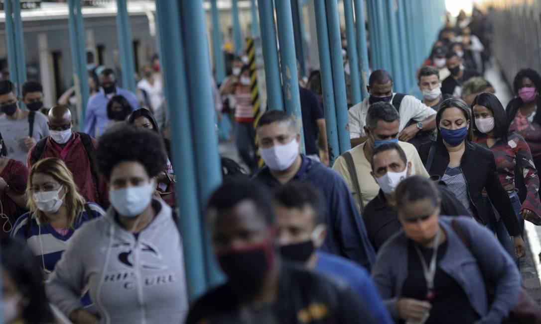 Passageiros descem do trem usando máscaras na estação da Central do Brasil. Foto: RICARDO MORAES / REUTERS