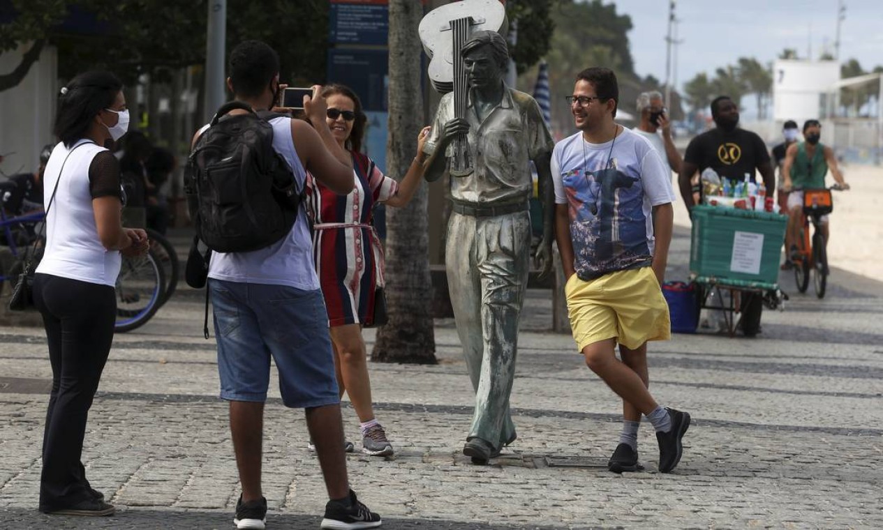 Pessoas tiram fotos ao lado da estátua de Tom Jobim, em Ipanema Foto: FABIANO ROCHA / Agência O Globo