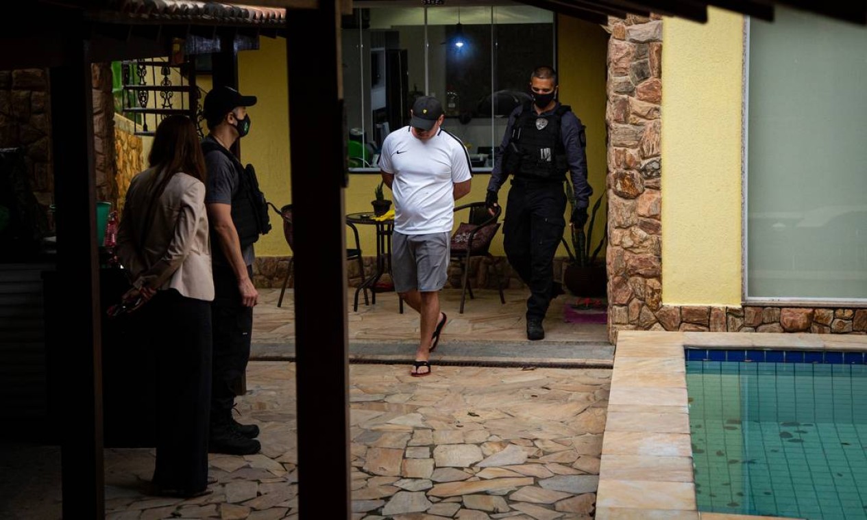 Devidamente vestido, Mag é algemado e levado para a Divisão de Homicídios, na Barra da Tijuca Foto: Hermes de Paula / Agência O Globo