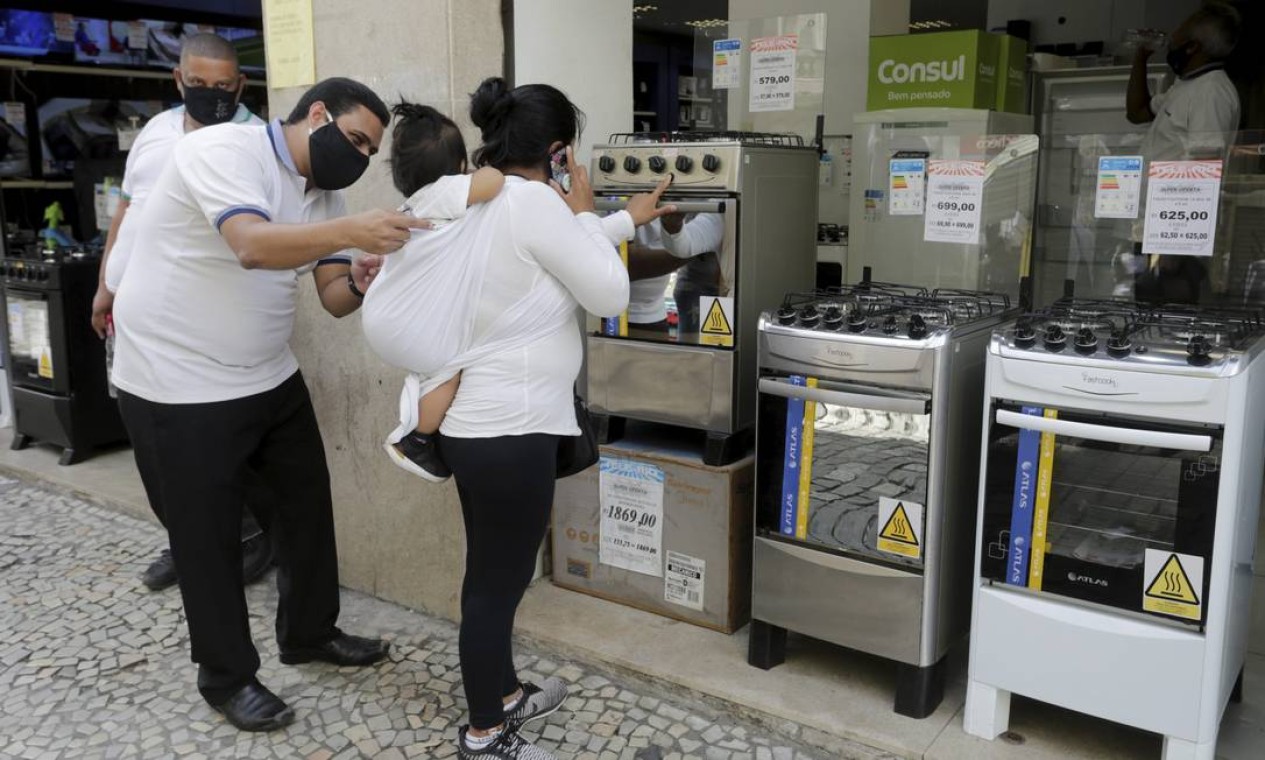 Vendedor atende uma cliente na frente de uma loja no centro do Rio Foto: Domingos Peixoto / Agência O Globo