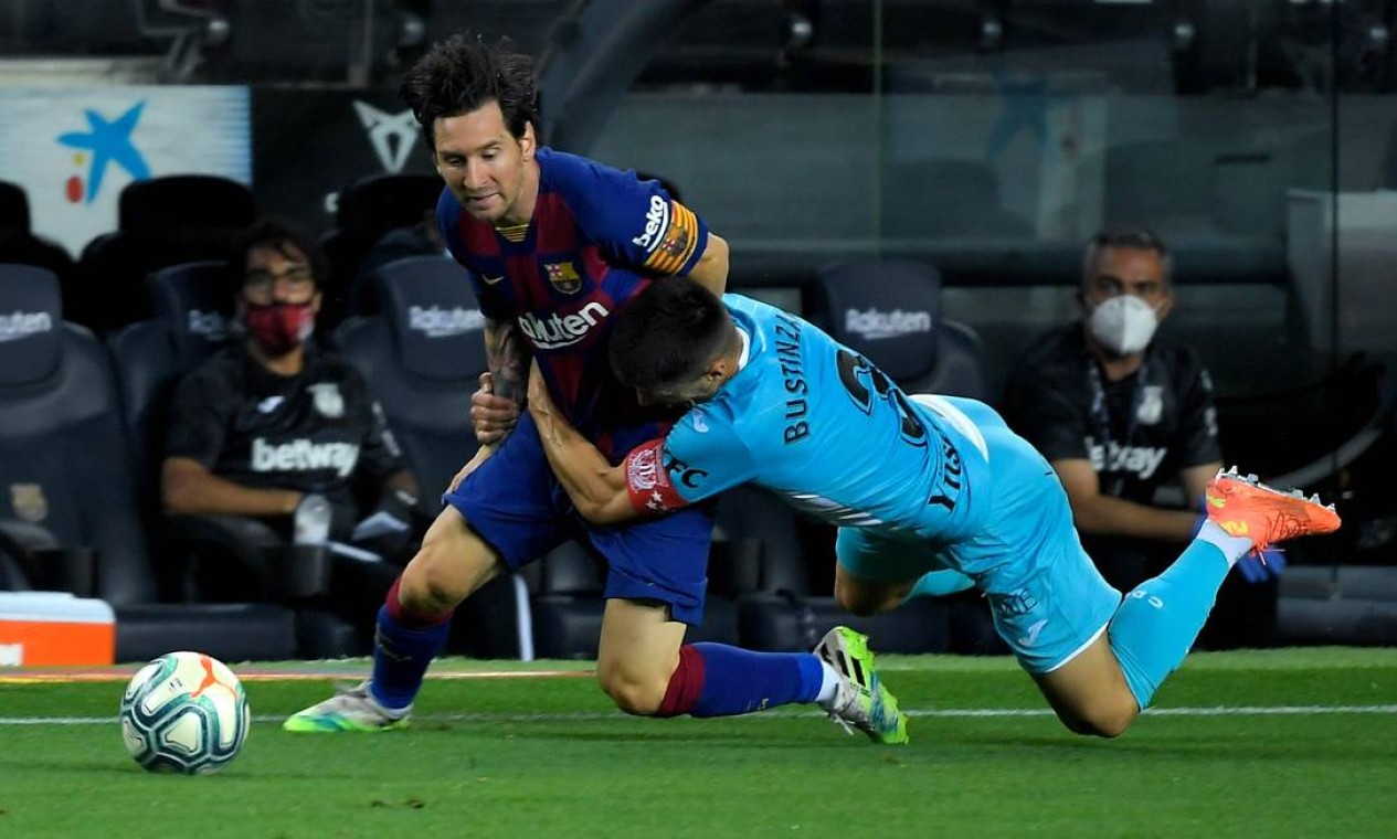 Messi é agarrado por zagueiro espanhol durante o jogo da liga espanhola, em junho de 2020. O Barcelona anunciou nesta quinta-feira (5) a saída definitiva do jogador Foto: LLUIS GENE / AFP