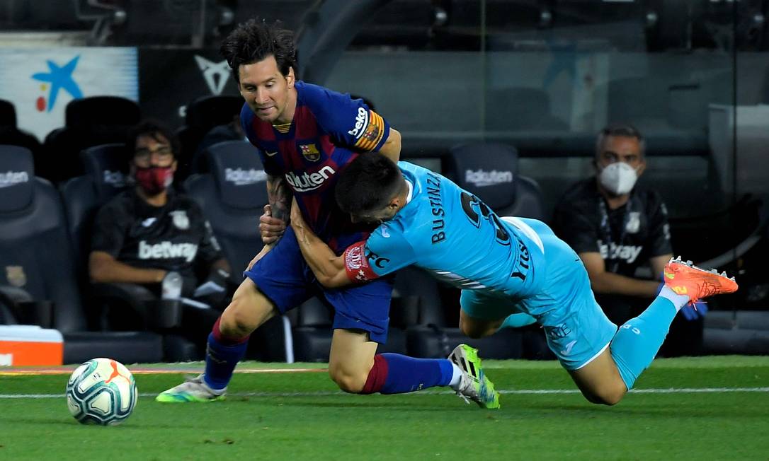 Messi é agarrado pelo zagueiro espanhol Legai, Unai Bustinza, durante o jogo da liga espanhola contra o CD Leganes, no Camp Nou, em Barcelona, em 16 de junho de 2020 Foto: LLUIS GENE / AFP