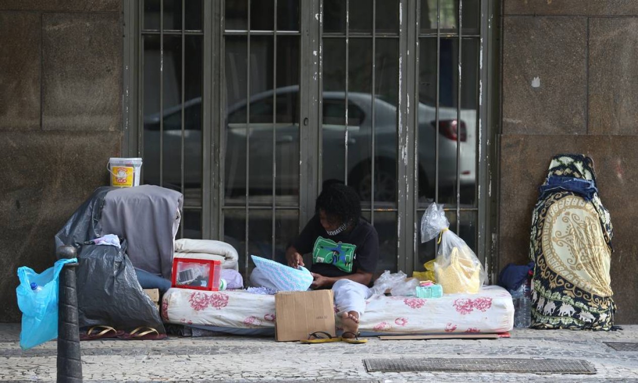 Uma mulher em situação de rua é vista com seus pertences na Rua Graça Aranha, no Centro Foto: Pedro Teixeira / Agência O Globo