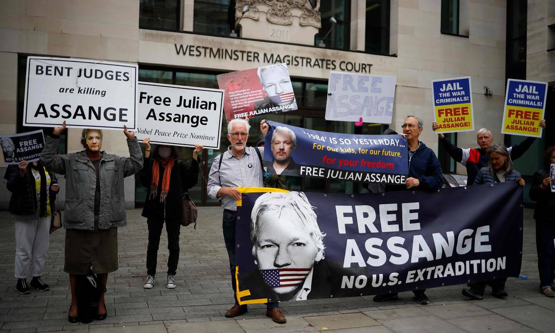 Apoiadores e ativistas seguram cartazes do lado de fora do tribunal de Westminster Magistrates, em Londres, pedindo a libertação de Assange Foto: TOLGA AKMEN / AFP/29-06-2020