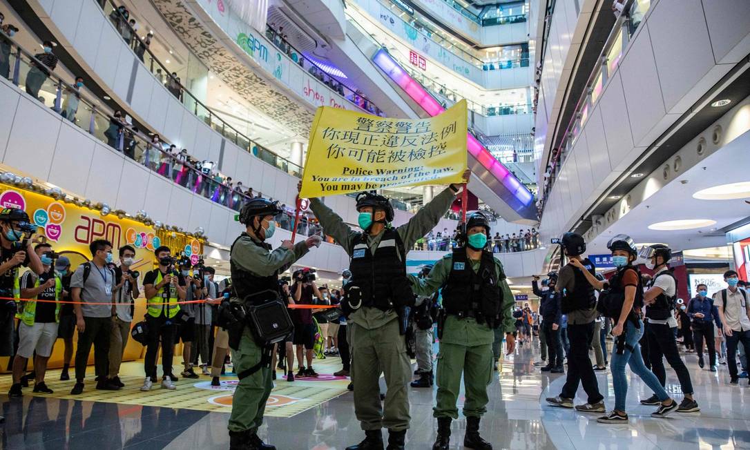 Polícia usa cartaz para alertar manifestantes que ocupam shopping em Hong Kong Foto: ISAAC LAWRENCE / AFP / 6-7-2020