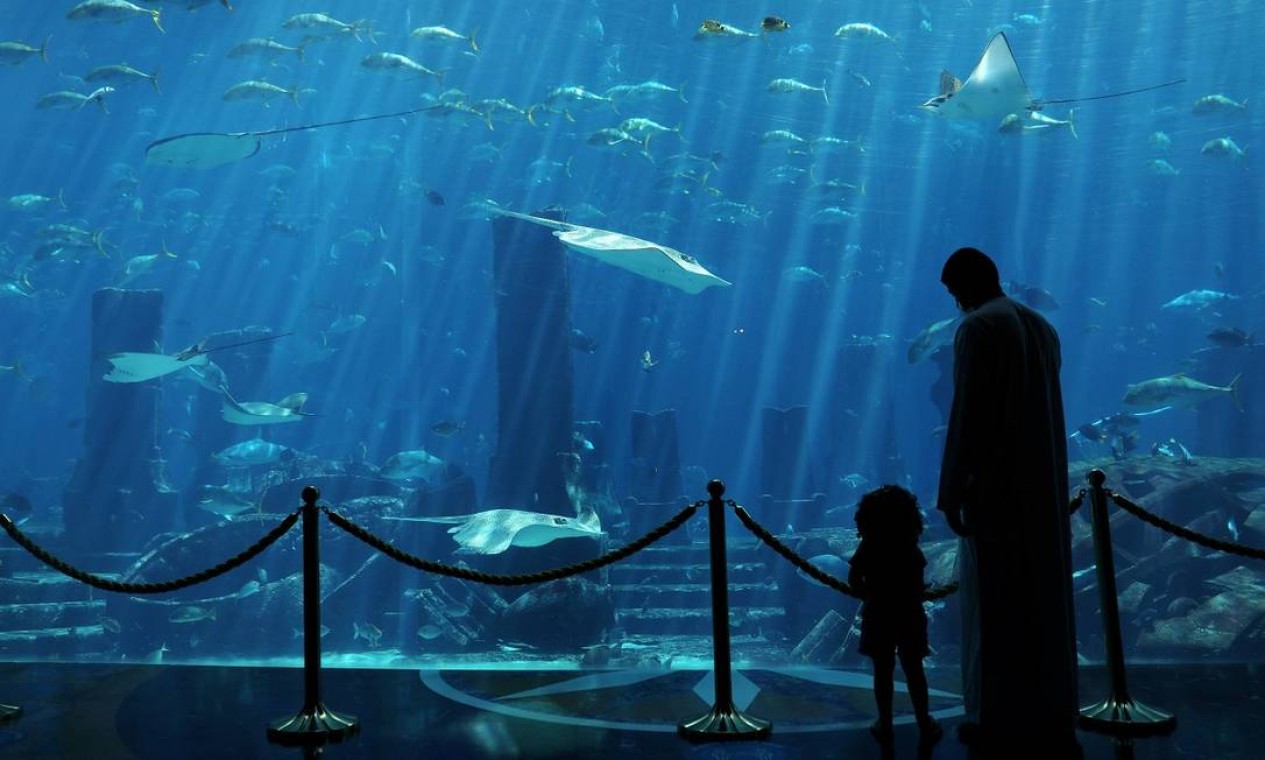 Pai e filha observam o aquário do Atlantis The Palm, uma das muitas atrações deste hotel em Dubai Foto: AHMED JADALLAH / REUTERS