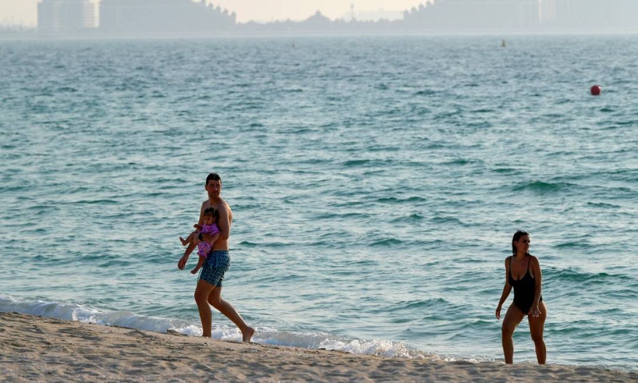 Banhistas aproveitam o dia de calor e a praia vazia em frente ao hotel Al Naseem, em Dubai Foto: KARIM SAHIB / AFP