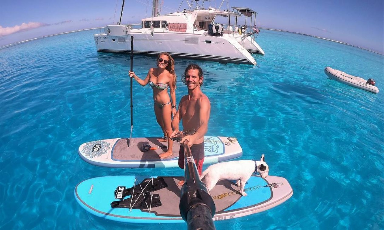 Sarah Moreira, Renato Matiolli e Feijão posam em frente ao veleiro Sail Ipanema, que passou a quarentena em Moorea, na Polinésia Francesa Foto: Acervo pessoal