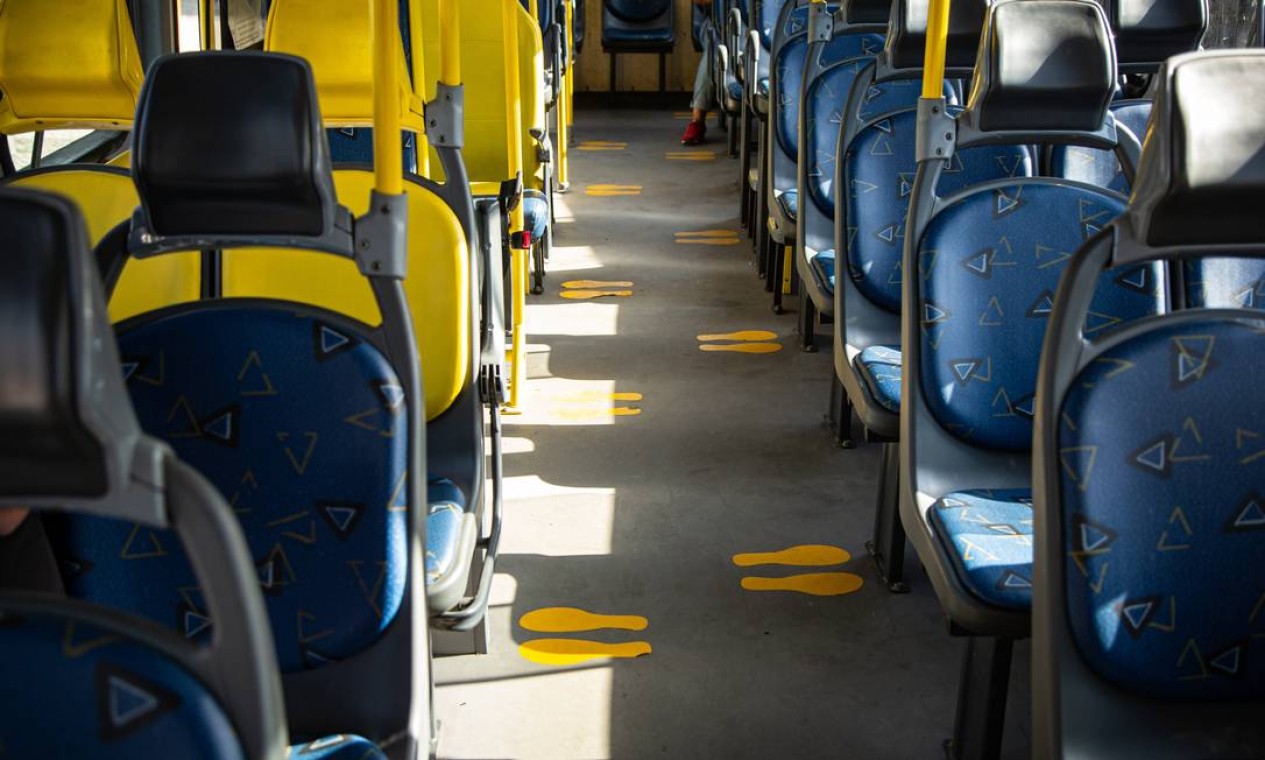 Expectativa: passageiros mantendo distanciamento social sinalizado com marcações no piso do ônibus Foto: Agência O Globo