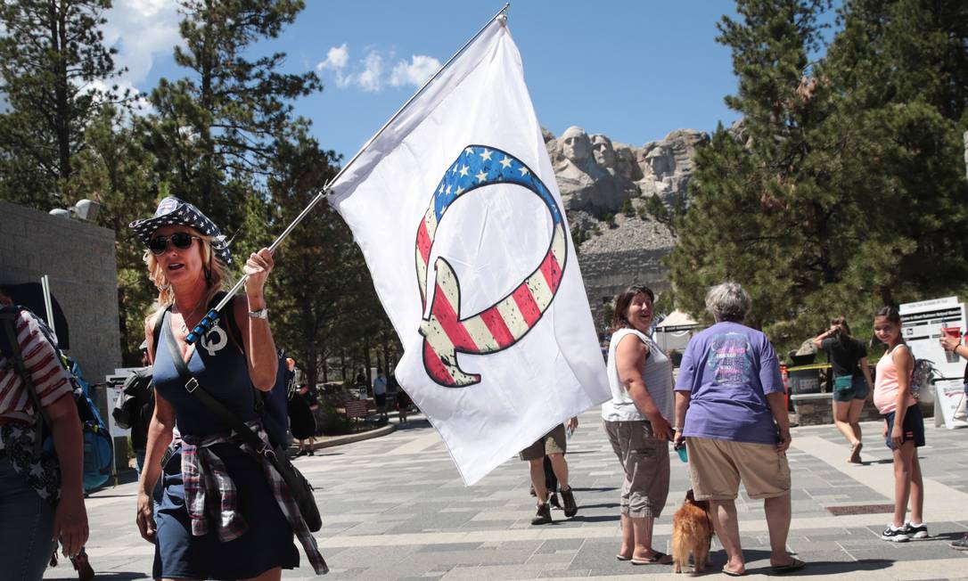 Apoiadora de Donald Trump carrega bandeira fazendo referência a QAnon em Keystone, nos EUA Foto: SCOTT OLSON / AFP