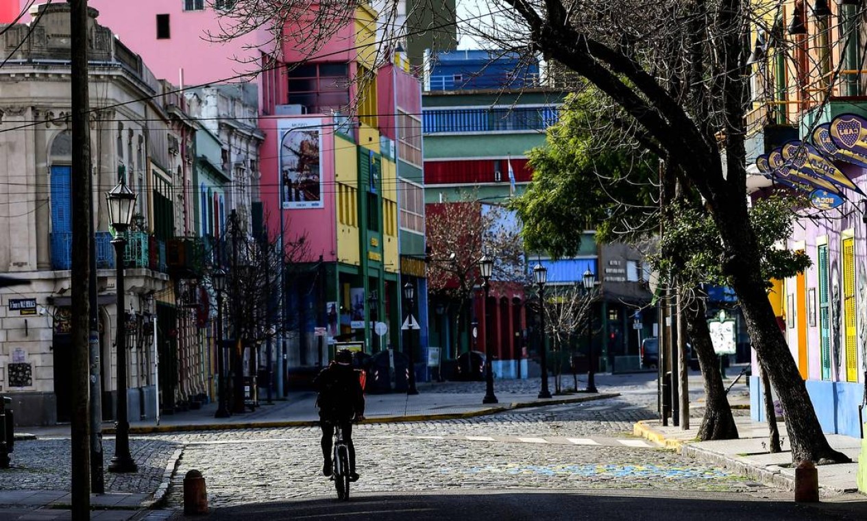 Homem pedala pelas ruas vazias de La Boca, em Buenos Aires Foto: RONALDO SCHEMIDT / AFP