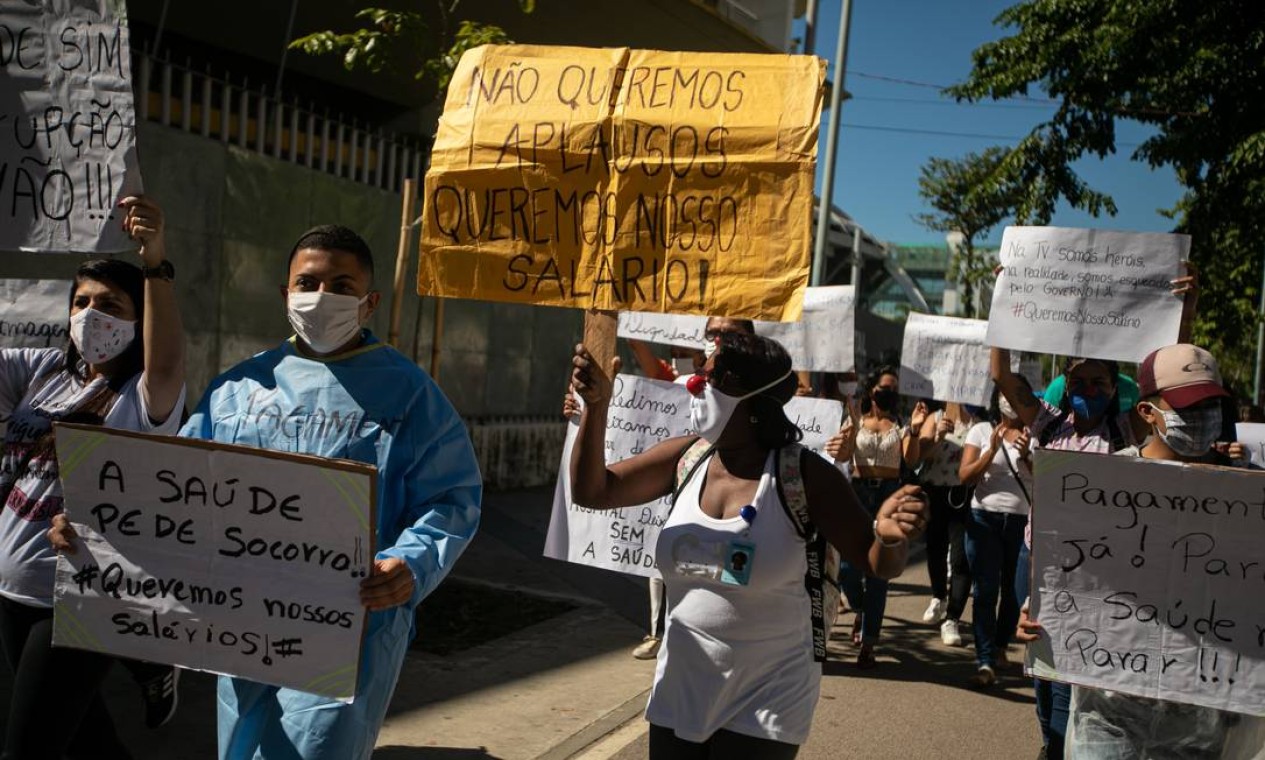 "Não queremos aplausos, queremos nosso salário!", diz o cartaz de profissional da saúde que participou de protesto na manhã desta segunda-feira, no entorno do hospital de campanha do Maracanã Foto: BRENNO CARVALHO / Agência O Globo