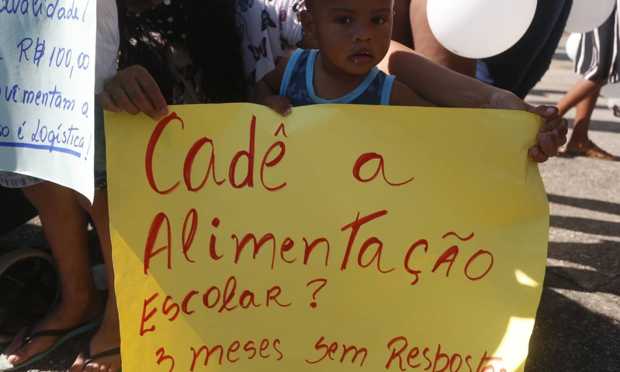 Criança segura cartaz que questiona sobre o desamparo da alimentação escolar devido ao fechamento das escolas no período da pandemia Foto: Fabiano Rocha / Agência O Globo