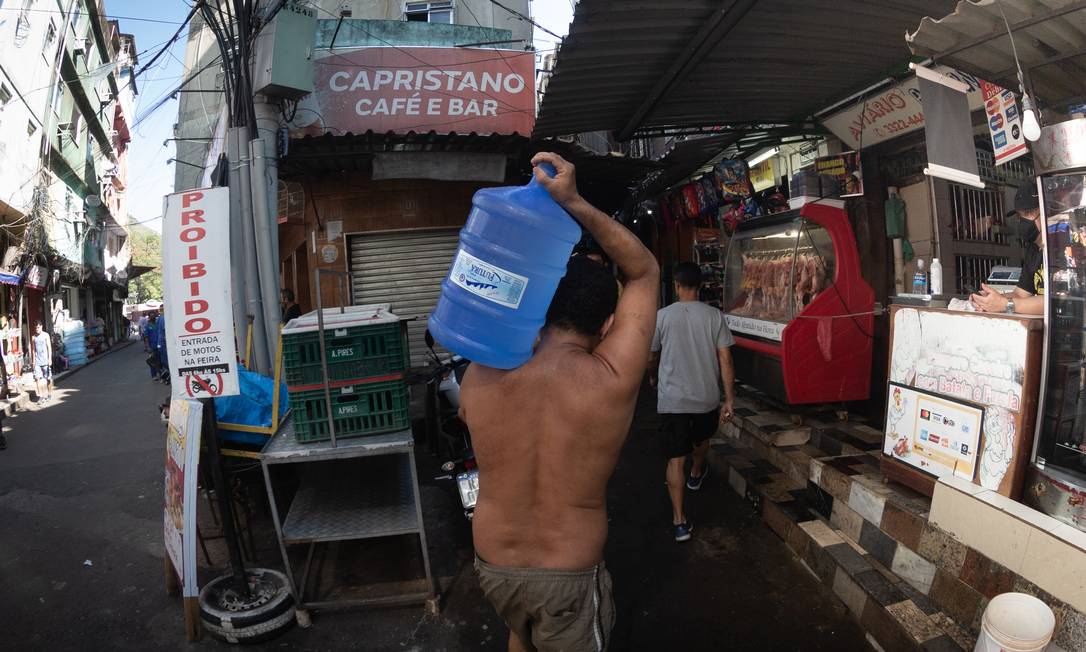 Localidade na parte baixa da comunidade está sem água há oito dias: moradores têm comprado galões ou recorrido a uma torneira na rua Foto: Roberto Moreyra / Agência O Globo