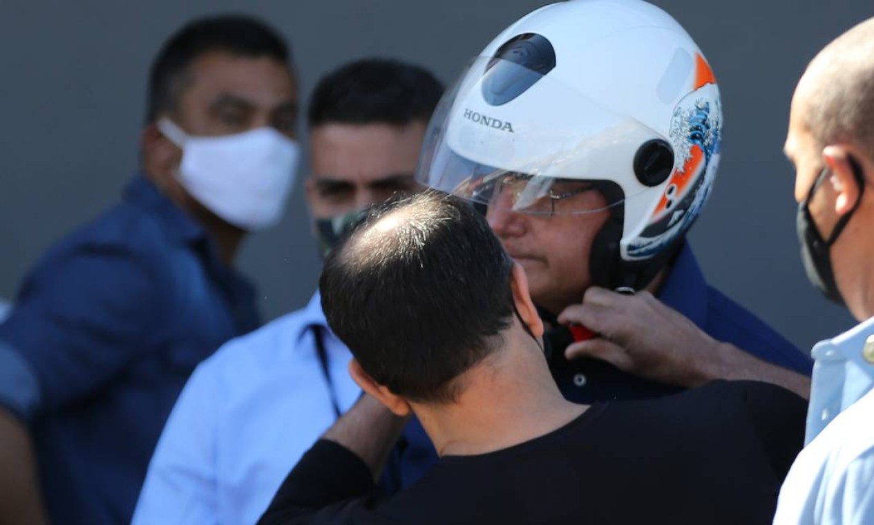 Presidente recebe ajuda com a questão da fivela do capacete Foto: Jorge William / Agência O Globo