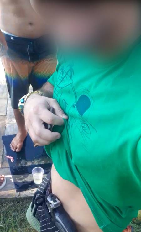 Homem mostra pistola na cintura, em imagens divulgadas em redes sociais Foto: Reprodução