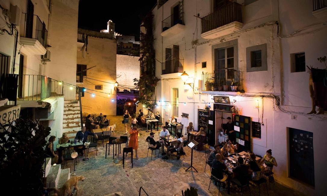 Pessoas estão sentadas em um bar na rua de la Virgen, em Ibiza; Espanha entra em recessão após queda histórica de 18,5% do PIB por conta da pandemia do coronavírus Foto: Jaime Reina / AFP
