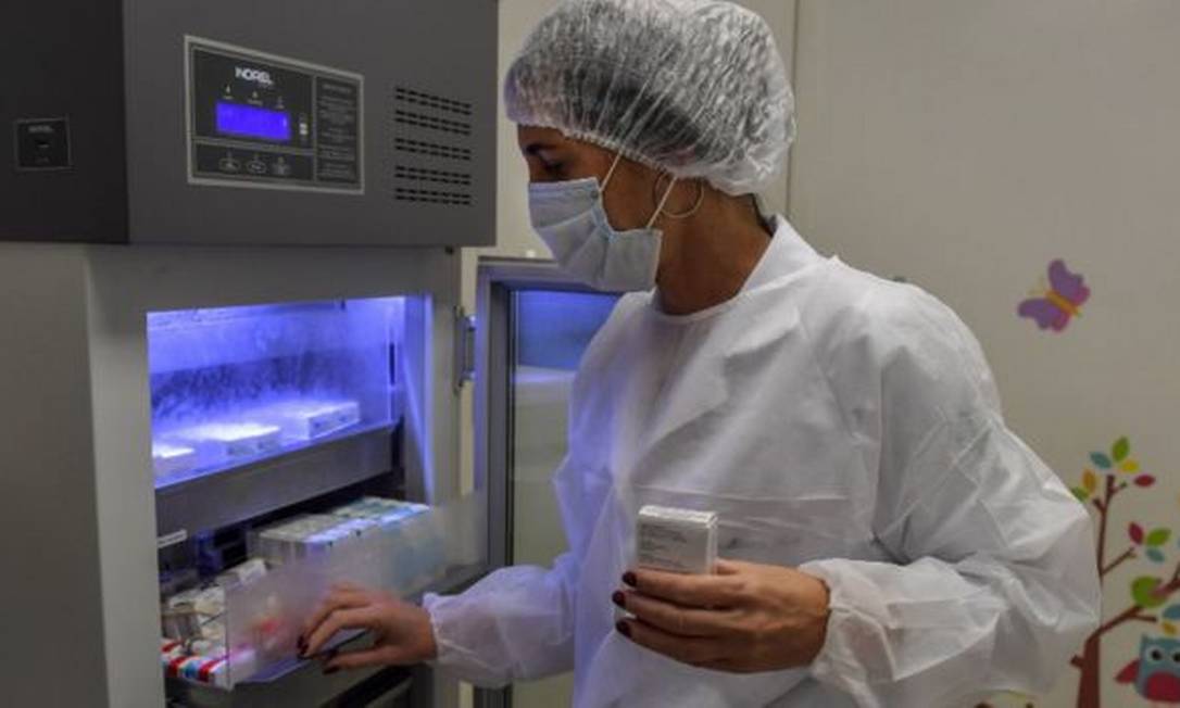 Tecnico aramazena doses de vacina em refrigerador em laboratóriol Foto: Getty Images