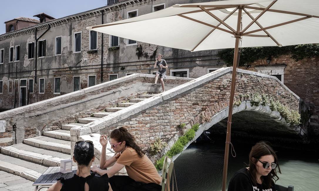 Visitantes às margens de um dos canais de Veneza, no momento em que o turismo começava a ser retomado na cidade Foto: Alessandro Grassani / The New York Times