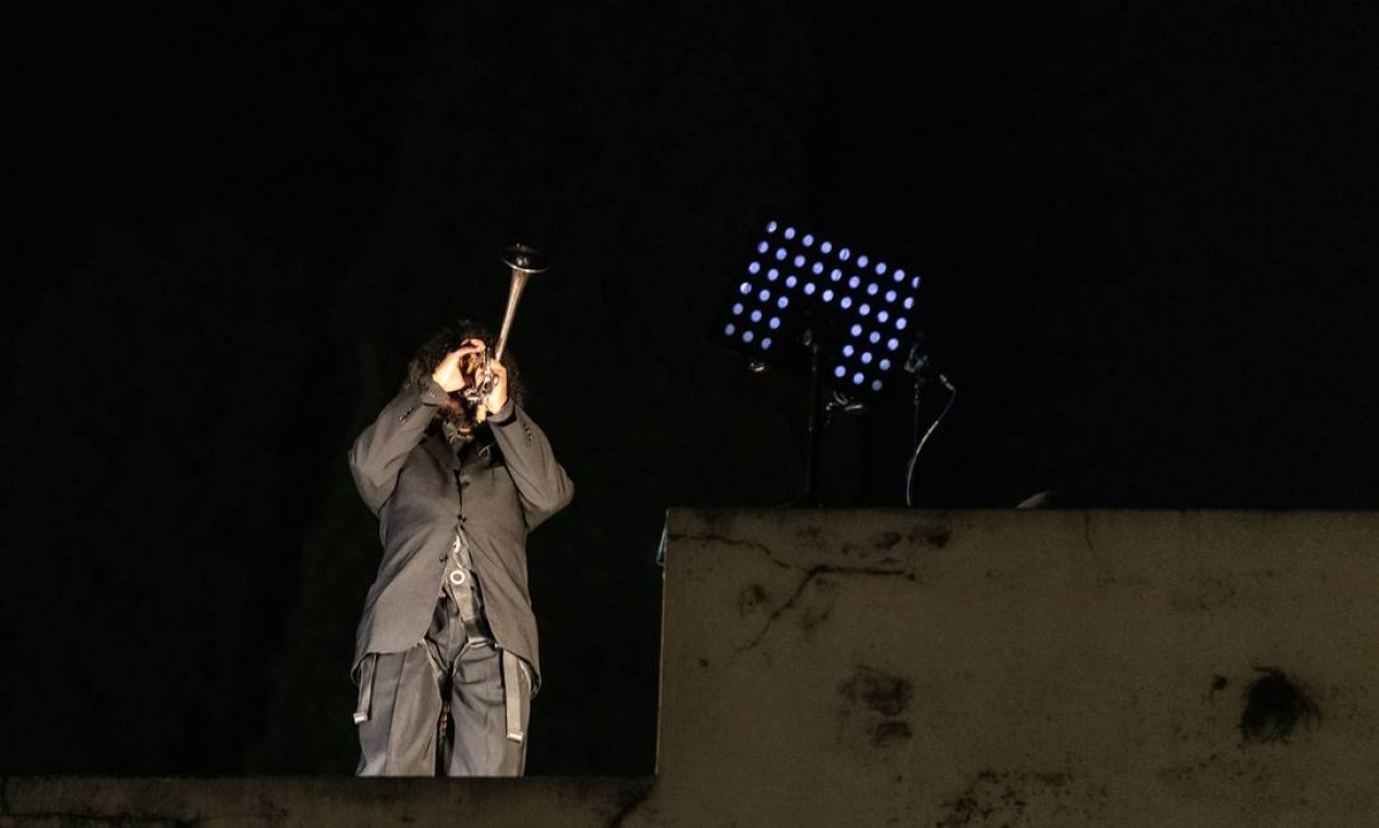 No final da performance, um músico executou o Hino Nacional de trás para frente em cima do portão de entrada do Cemitério da Consolação Foto: Matheus Maria José / Divulgação