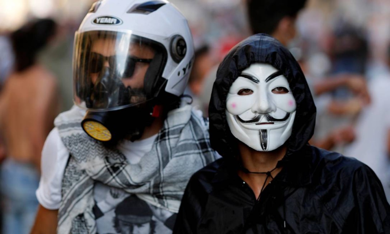 Manifestantes aparecem usando máscara durante protesto, nesta segunda-feira, em Beirute Foto: THAIER AL-SUDANI / REUTERS