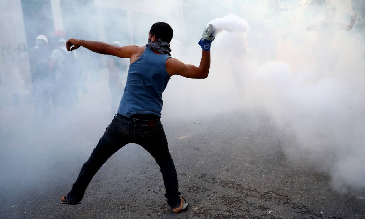 Manifestante lança de volta gás lacrimogêneo disparado pela polícia, durante protesto, em Beirute, Líbano, nesta segunda-feira Foto: HANNAH MCKAY / REUTERS