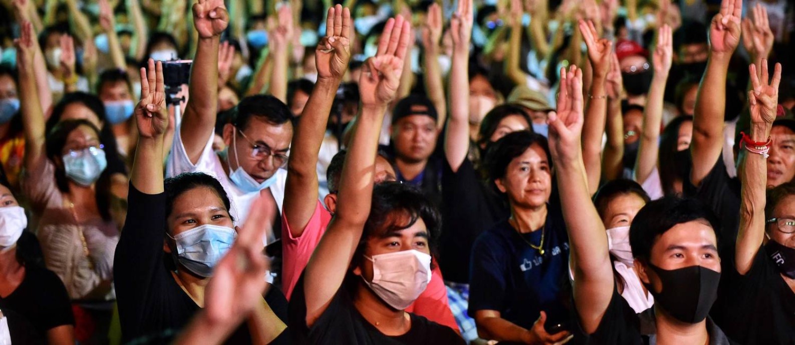 Manifestantes na Tailândia fazem o mesmo sinal com três dedos que é feito na saga Jogos Vorazes Foto: Lillian Suwanrumpha / AFP