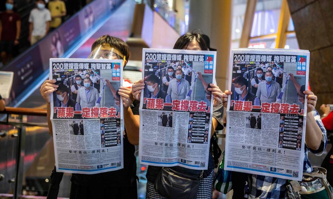 Ativistas pró-democracia carregam edições do Apple Daily, jornal de Jimmy Lai, magnata preso na segunda-feira Foto: ISAAC LAWRENCE / AFP