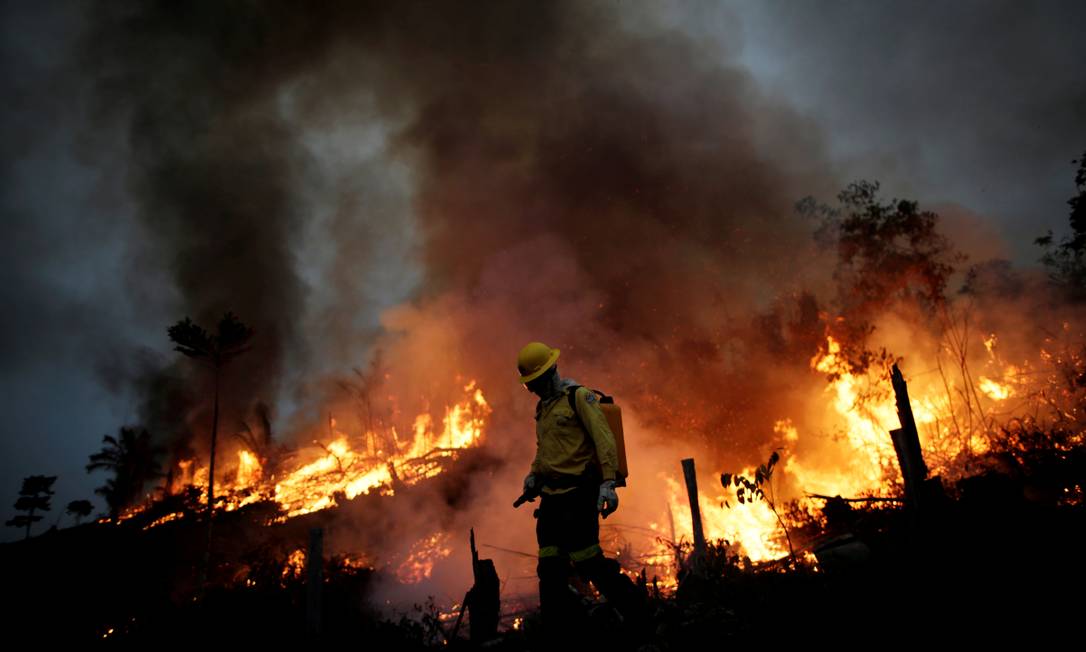 Membro da brigada de incêndio do Instituto Brasileiro do Meio Ambiente e dos Recursos Naturais Renováveis (Ibama) tenta controlar um incêndio em uma área da floresta amazônica, em Apuí, no Amazonas Foto: UESLEI MARCELINO / REUTERS
