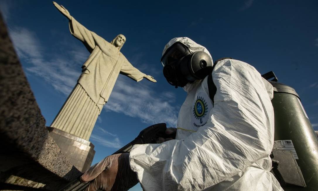 Militar limpa o Cristo Redentor antes da reabertura do monumento aos visitantes Foto: Brenno Carvalho / Agência O Globo