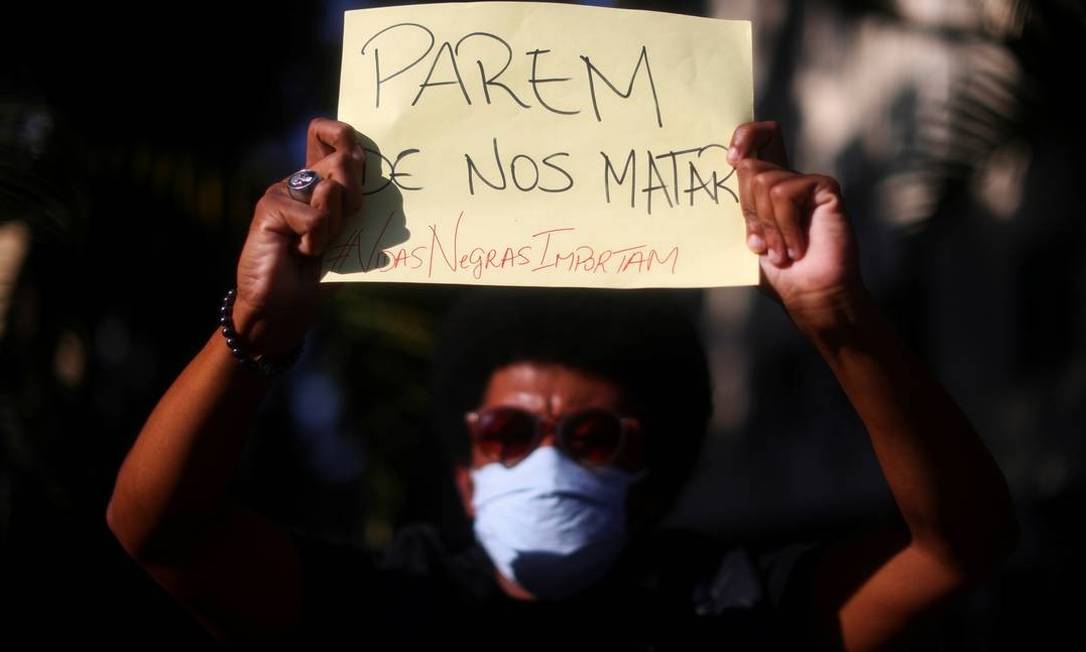 Manifestante mostra cartaz com a inscrição 'Parem de nos matar' no protesto Vidas Negras Importam, em maio, na Zona Sul do Rio de Janeiro Foto: Roberto Moreyra