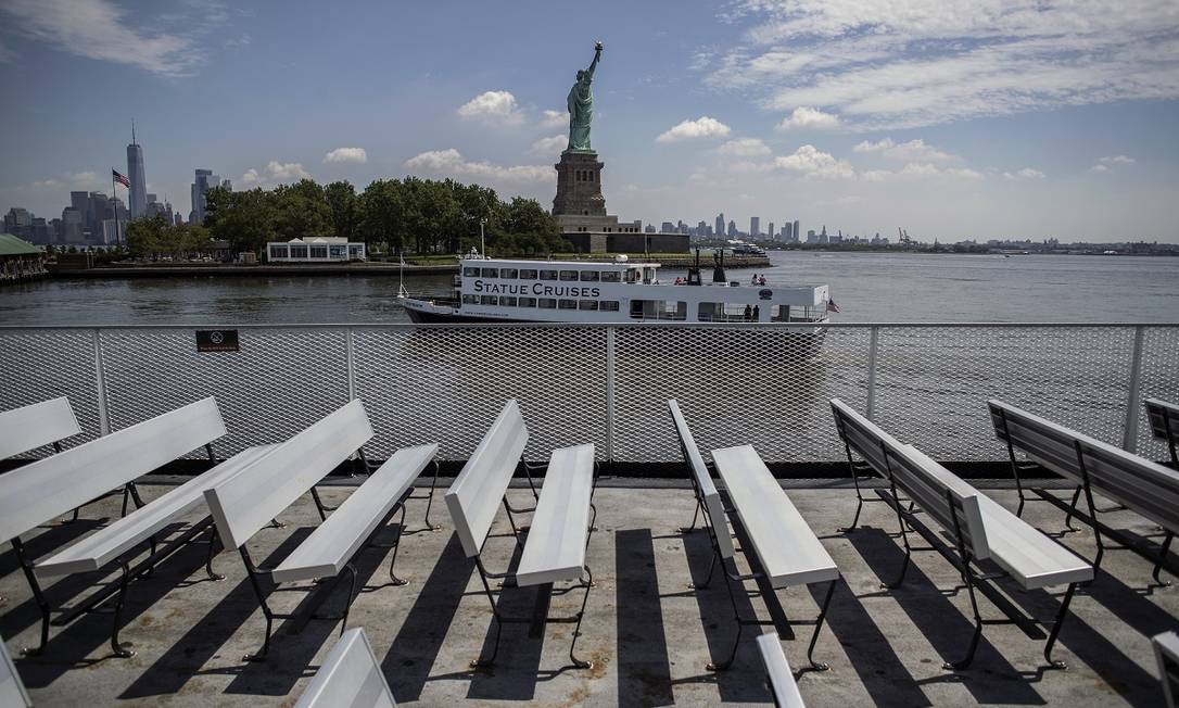Um barco turístico passa em frente à Estátua da Liberdade, na Liberty Island, em Nova York Foto: Victor J. Blue / The New York Times