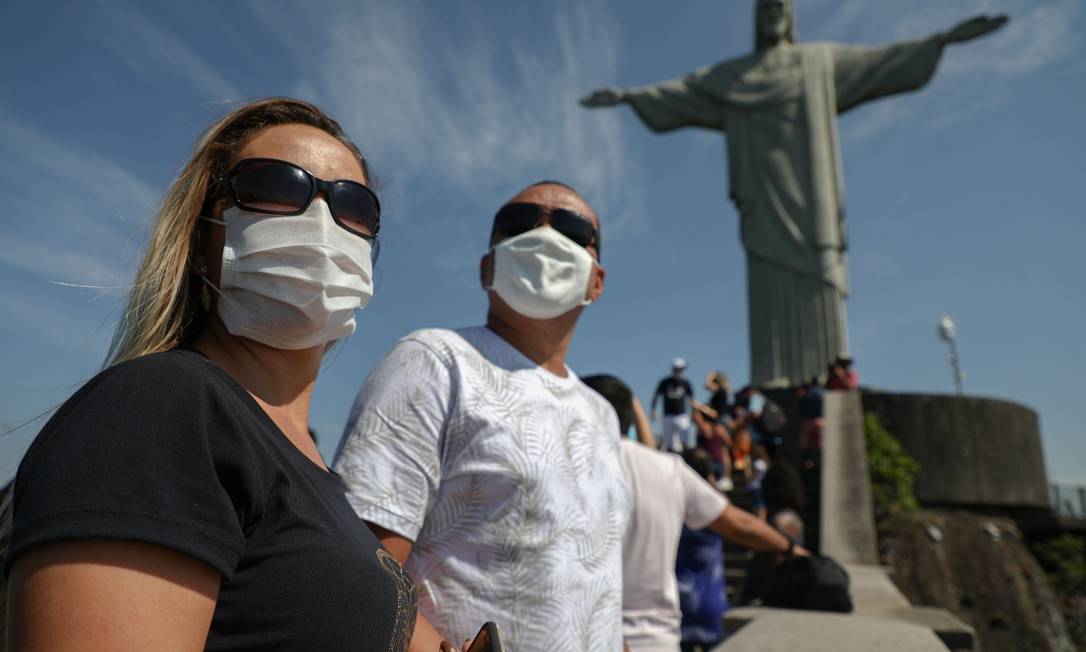 De máscaras, pessoas visitam estátua do Cristo Redentor, no Rio de Janeiro, em sua reabertura Foto: FABIO MOTTA / AFP / 15-8-2020