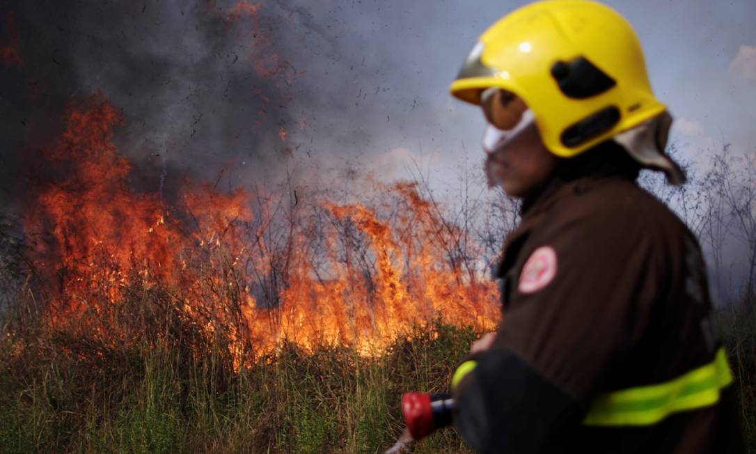 Moradores e bombeiros no noroeste do Brasil estão lutando contra os incêndios que assolam a Amazônia, destruindo terras agrícolas e ameaçando suas casas, em Porto Velho Foto: UESLEI MARCELINO / REUTERS
